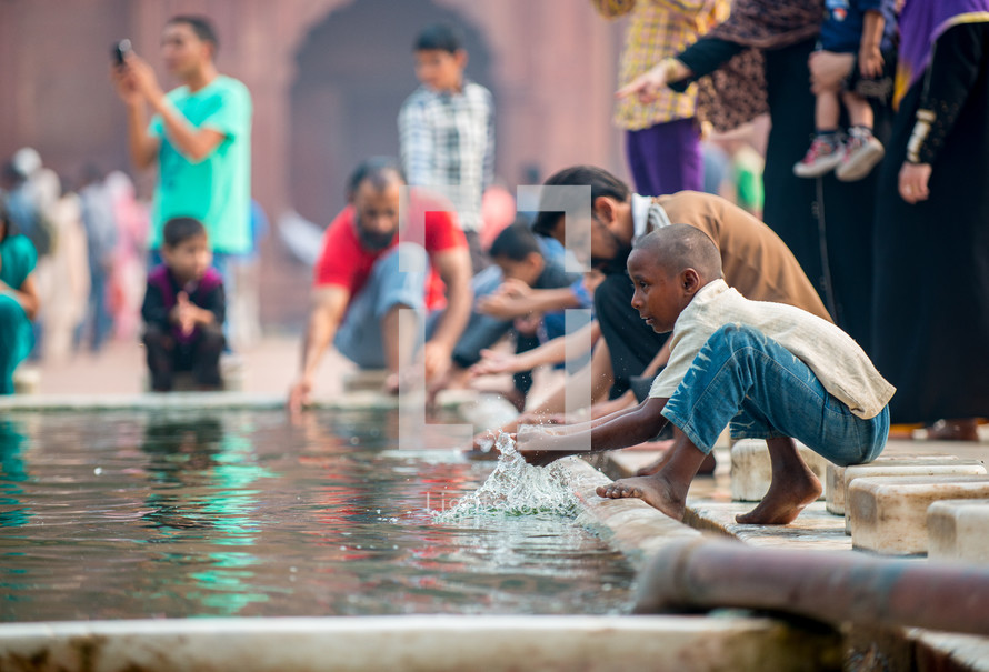 people washing their hands in a courtyard of a mosque in Delhi, India 
