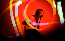 man with swirling lights at a performance with his hand over his face