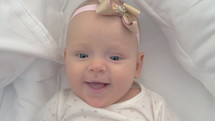 Portrait of smiling blue-eyed baby girl of six months old
