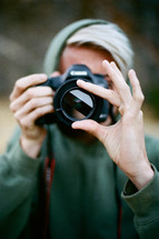 person holding a camera and focusing 