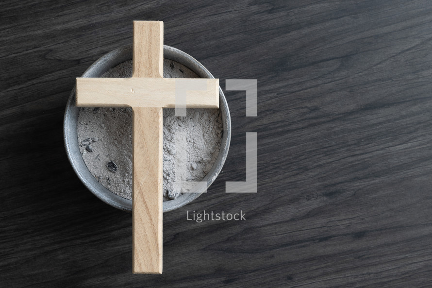 Small wood cross on a bowl of ashes