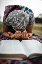 girl kneeling before a Bible 