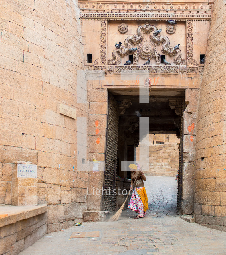 a woman sweeping the streets in India 