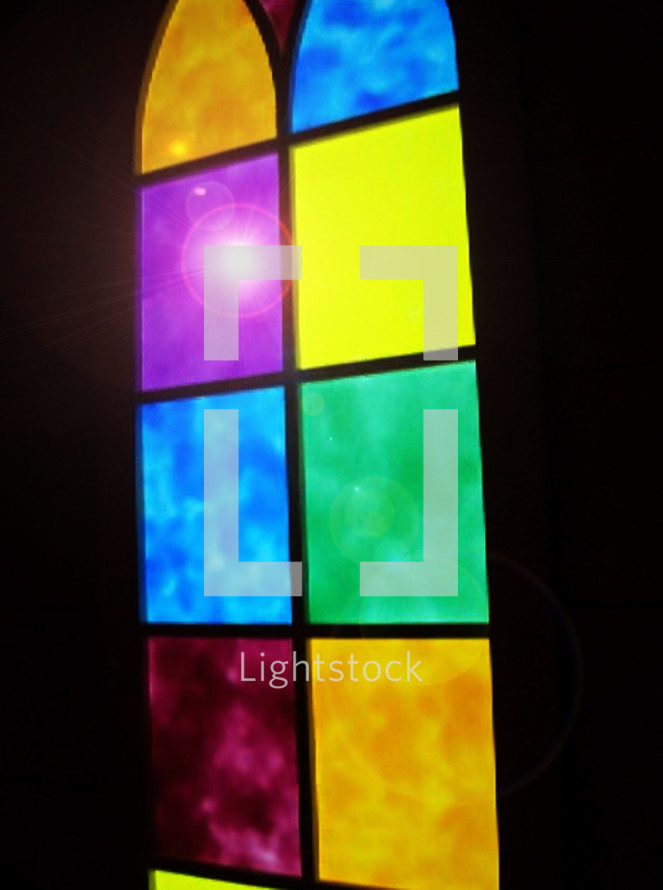 A multi colored stained glass window with various colored panels including yellow, gold, red, mauve, purple and blue bring light into a sanctuary or church building during Sunday Morning Worship time. 
