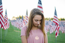 A woman praying near patriotic Valor Flags
