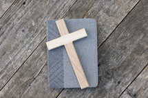 Cross on book and rustic wood
