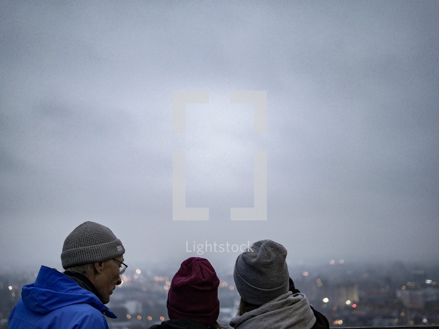 people looking out at a view over a foggy city in Poland 