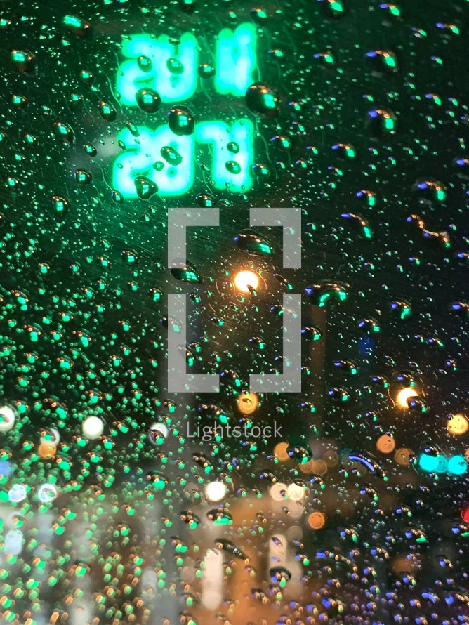 rain drops on glass in a city at night 