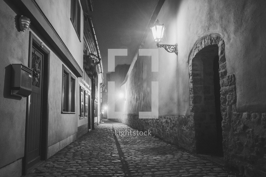 lights over a cobblestone street at night 