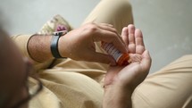 Man Taking Pill from Prescription Bottle
