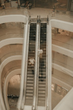 couple standing on an escalator 