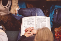 Bible in the lap of a woman sitting in church 