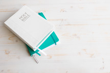 Bible and journal on a white wood background 