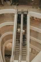 couple standing on an escalator 