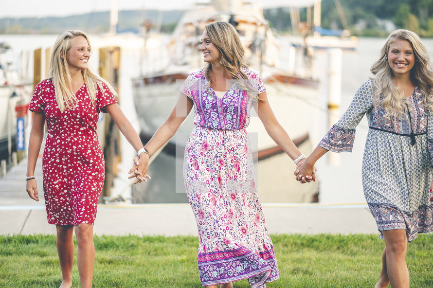 barefoot women standing on a boat dock at a marina 