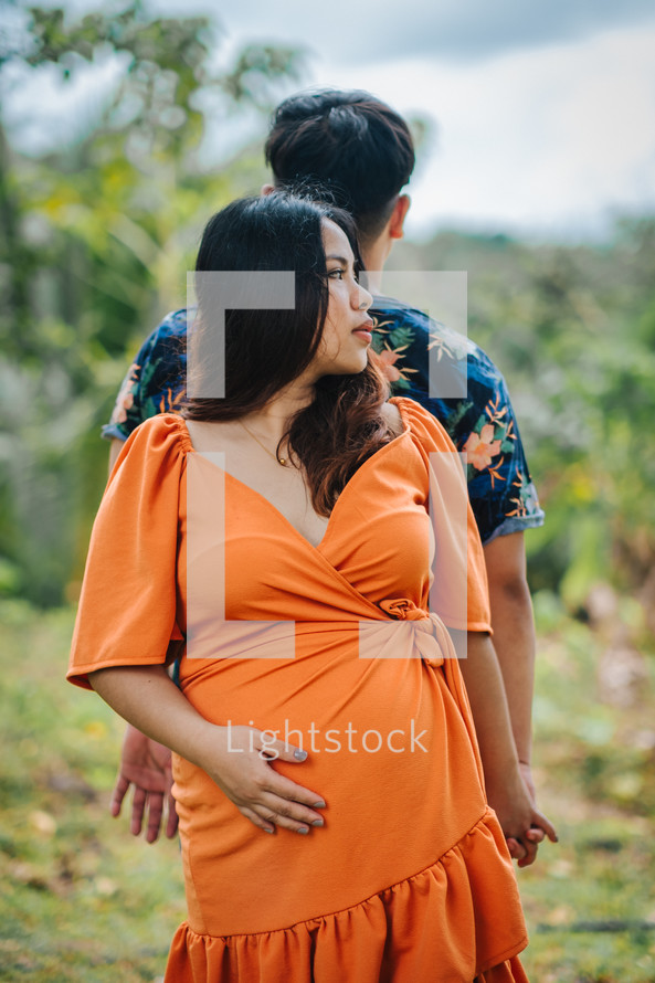 portrait of an expecting couple in a garden 