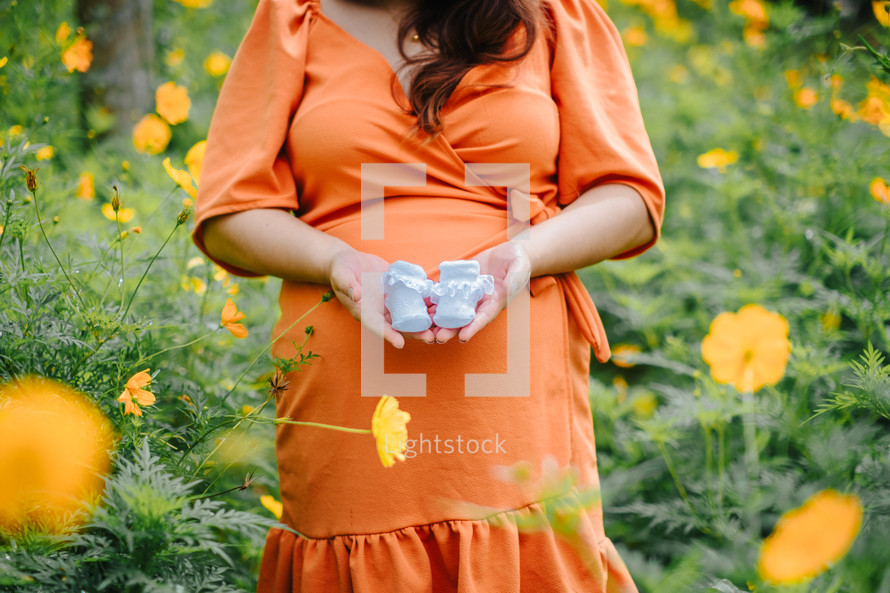 pregnant woman holding baby booties 