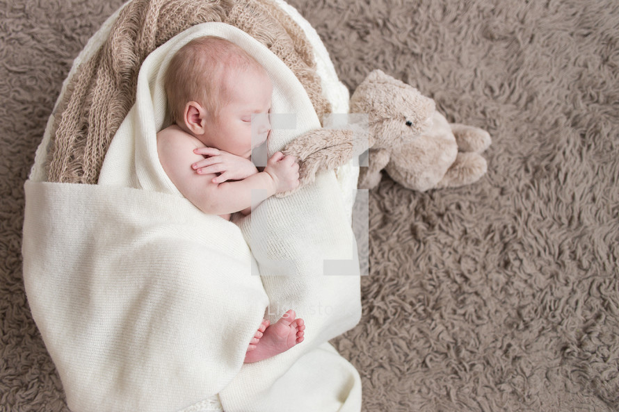 newborn holding a stuffed animal 