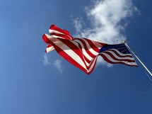 American flag waiving against the blue sky
