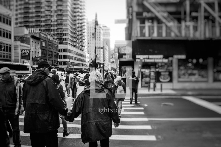people using a crosswalk in a city 