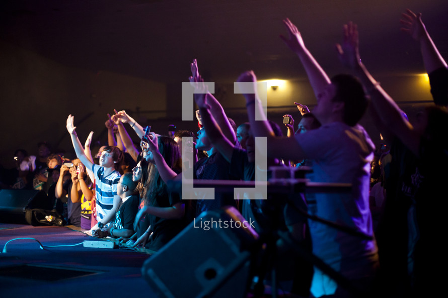 A group of young people lifting their hands in worship