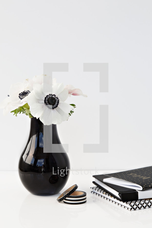 flowers in a black vase and journal 