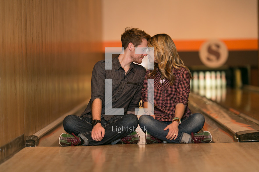 Couple sitting in a bowling alley lane