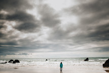 a girl standing on a beach 