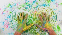 Hands Touching Holi Colored Powder On White Sheet