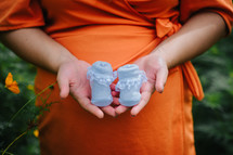 an expectant mother holding baby booties 