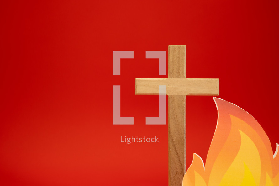 Cross and flame on a red background with copy space