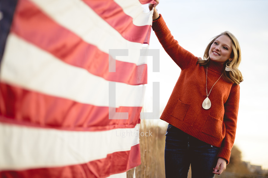 smiling woman holding an American flag 
