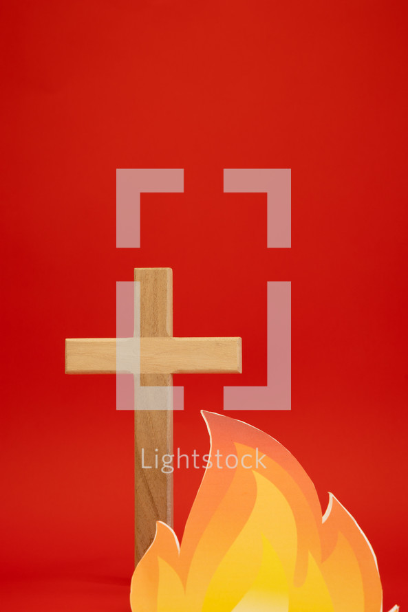 Cross and flame on a red background with copy space