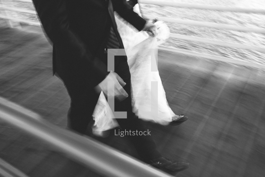 bride and groom walking on a pier 