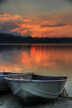 rental boats on a lake shore at sunset