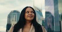 Young woman admiring downtown city buildings and scenery during sunset