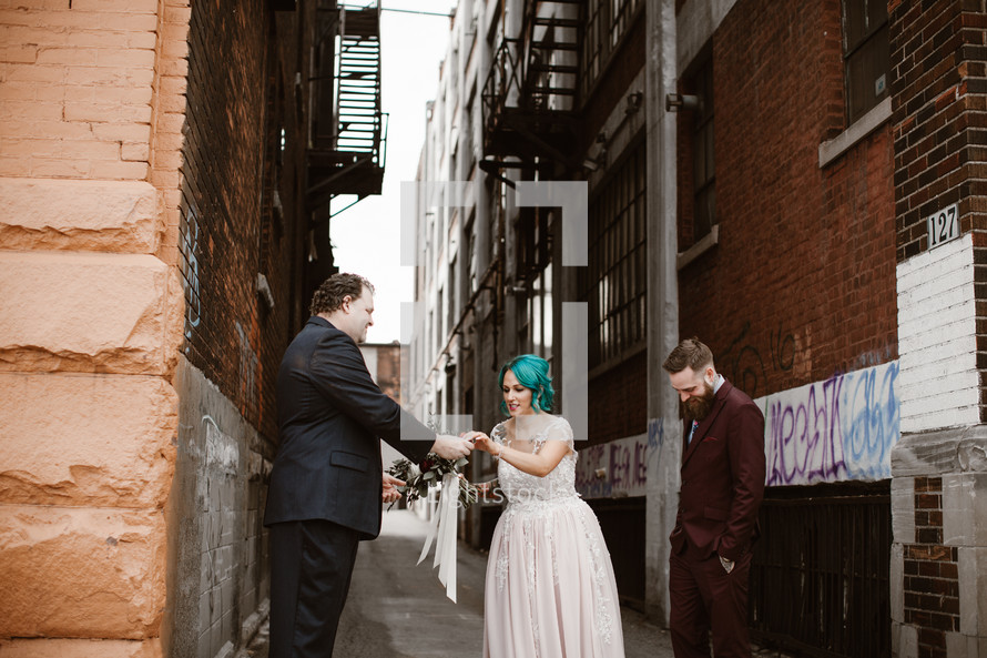 bride and groom standing in an alley 