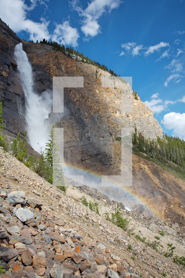 waterfall with rainbow - mountain cliff