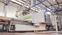 Automated wood processing machine in a furniture manufacturing facility