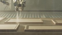 Automated wood painting robot spraying wood plates in a furniture production facility