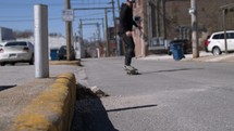 a man riding a skateboard on a sidewalk 