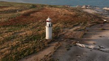 Aerial Approach to Lighthouse on Island with Hundreds of Seagulls Taking Flight