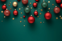 Hanging brightly colored Christmas baubles on a green background with scattered gold stars