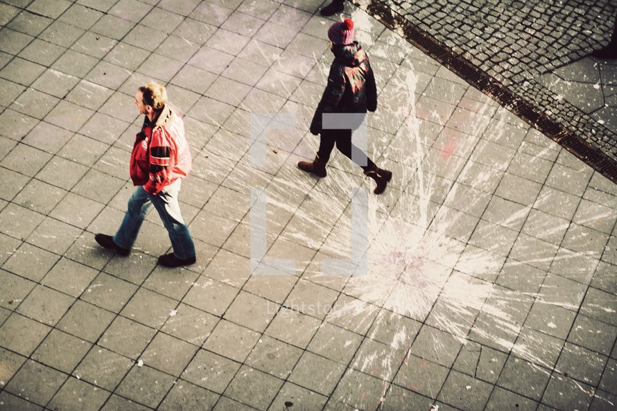 men walking and paint splatter on a  courtyard 