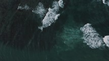 Aerial top down of crashing waves of blue Ocean in Costa Rica during summer	