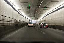 Cars driving through a long tunnel.