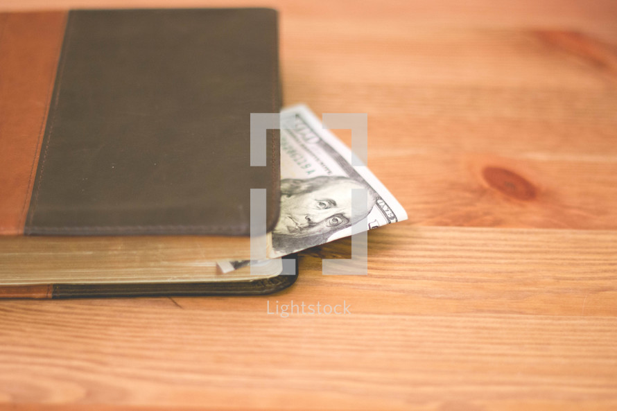 one hundred dollar bill in a Bible 