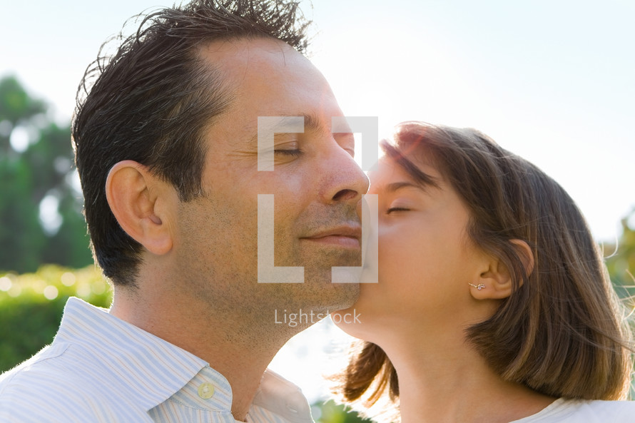 little girl kissing her dad on the cheek