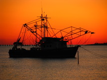 Silhouette of a fishing boat against a beautiful sunset.