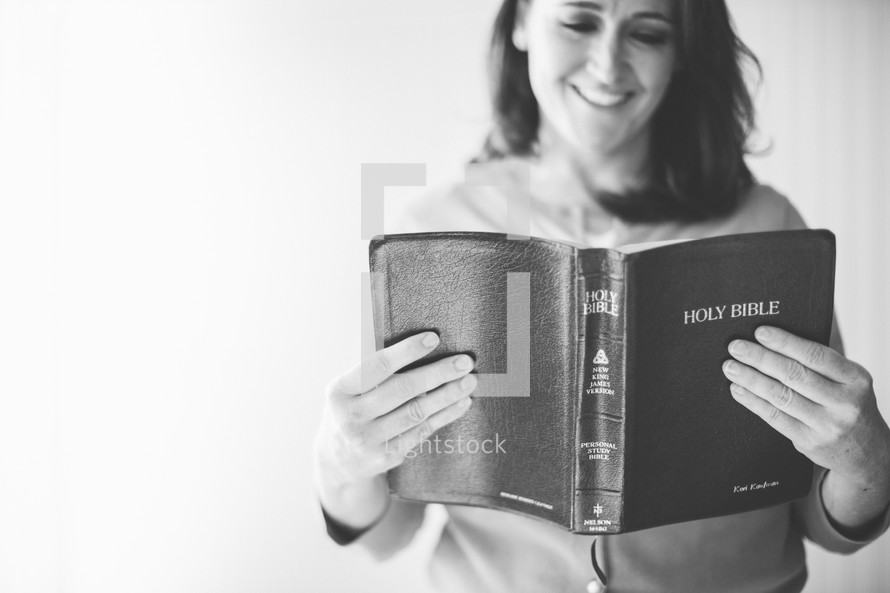 smiling woman reading a Bible
